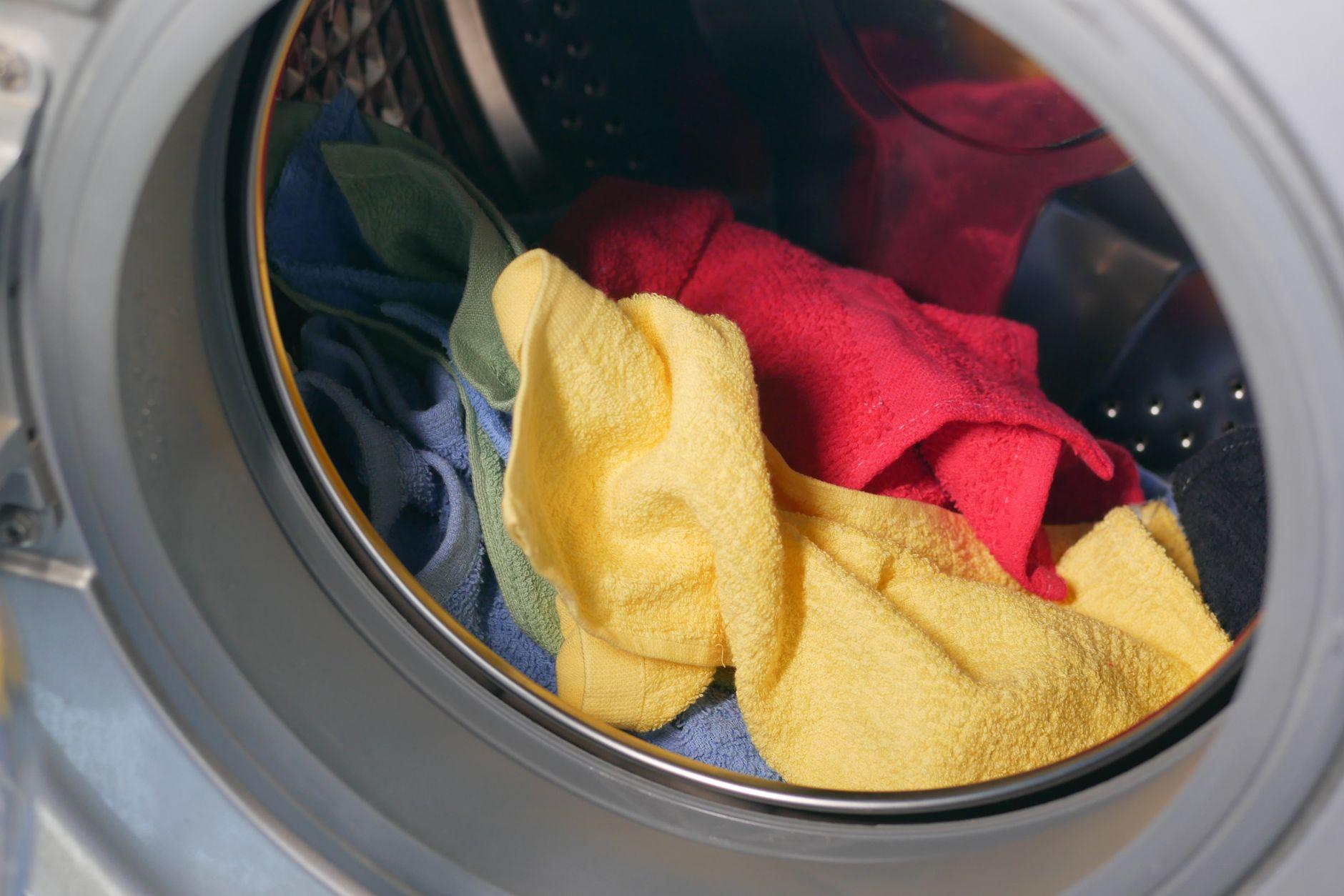 Vibrant close-up of multicolored towels inside a washing machine, ready for a wash.